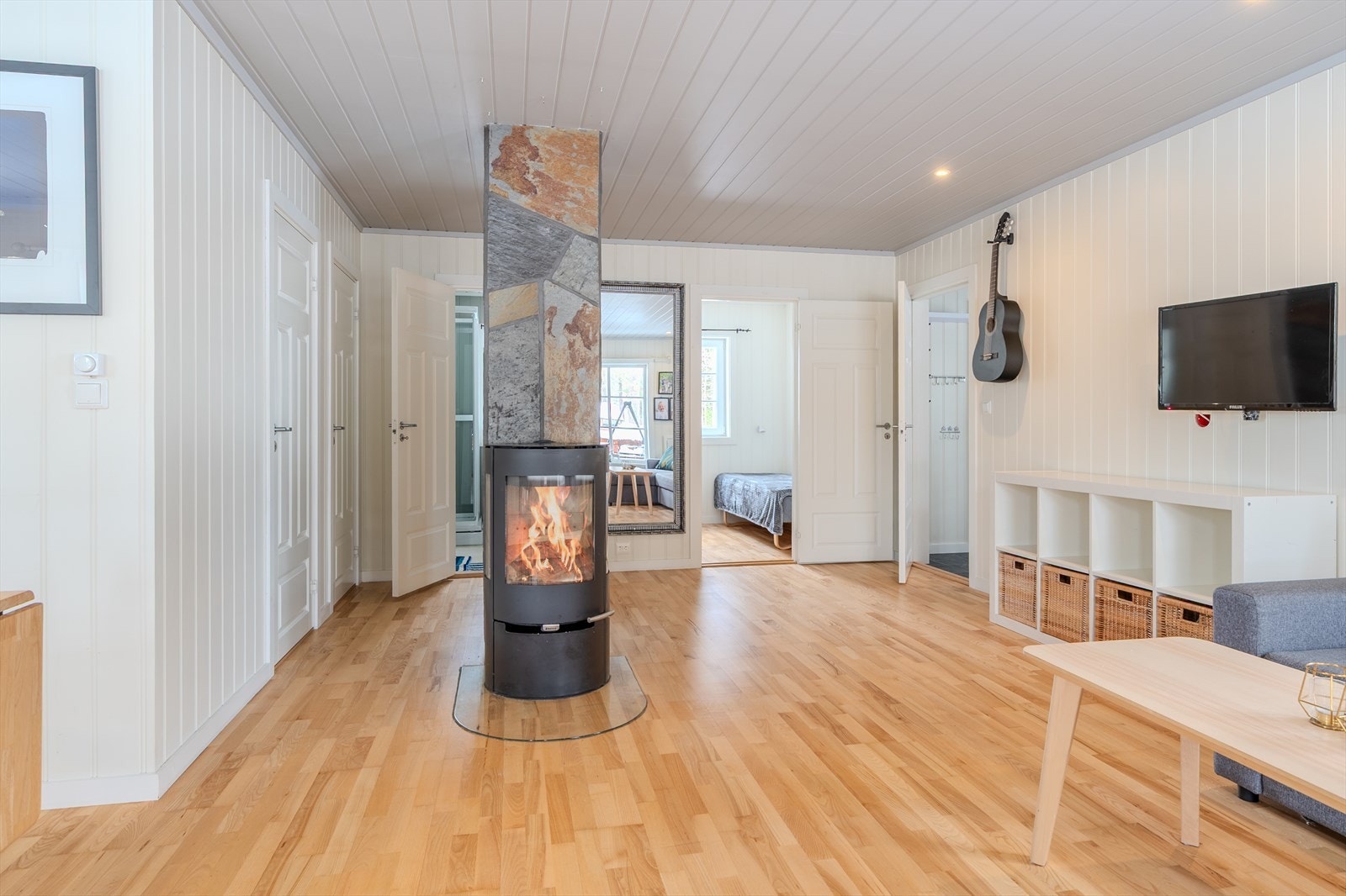 Spotter i himling og skiferkledd pipe med varmende Aduro peisovn Galleribilde