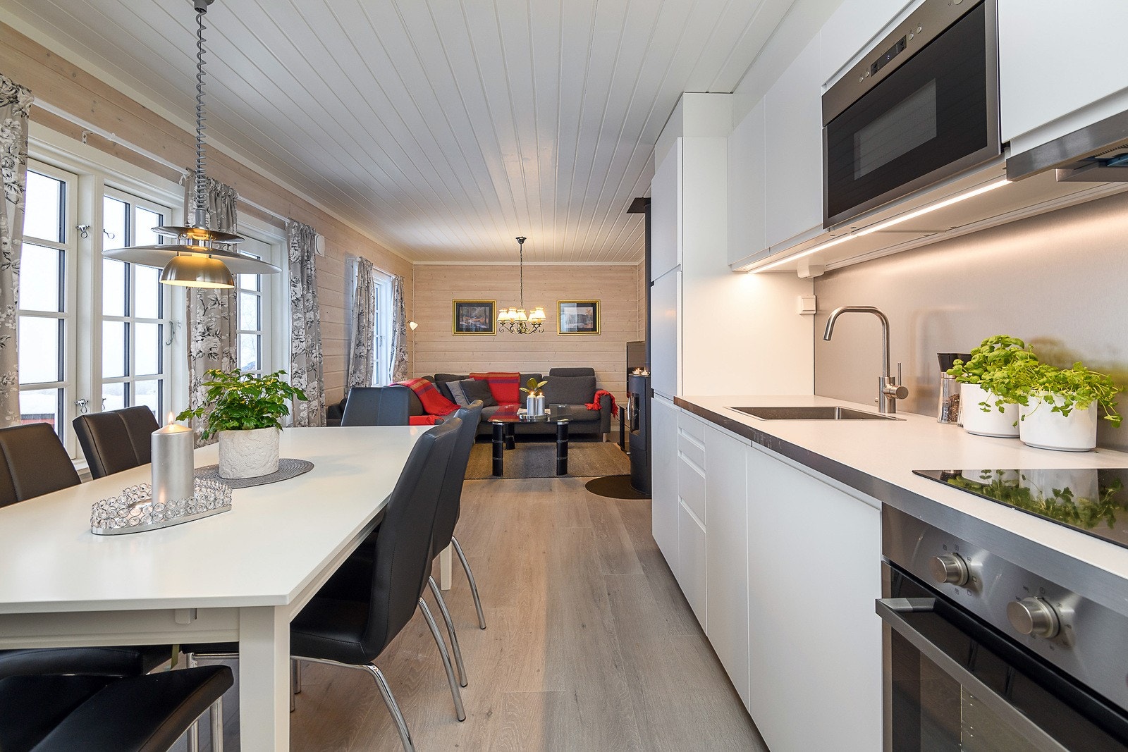 Pen og moderne kjøkkeninnredning fra IKEA, ny i 2018. Innredningen har hvite slette fronter og overskap helt opp til taket. Galleribilde