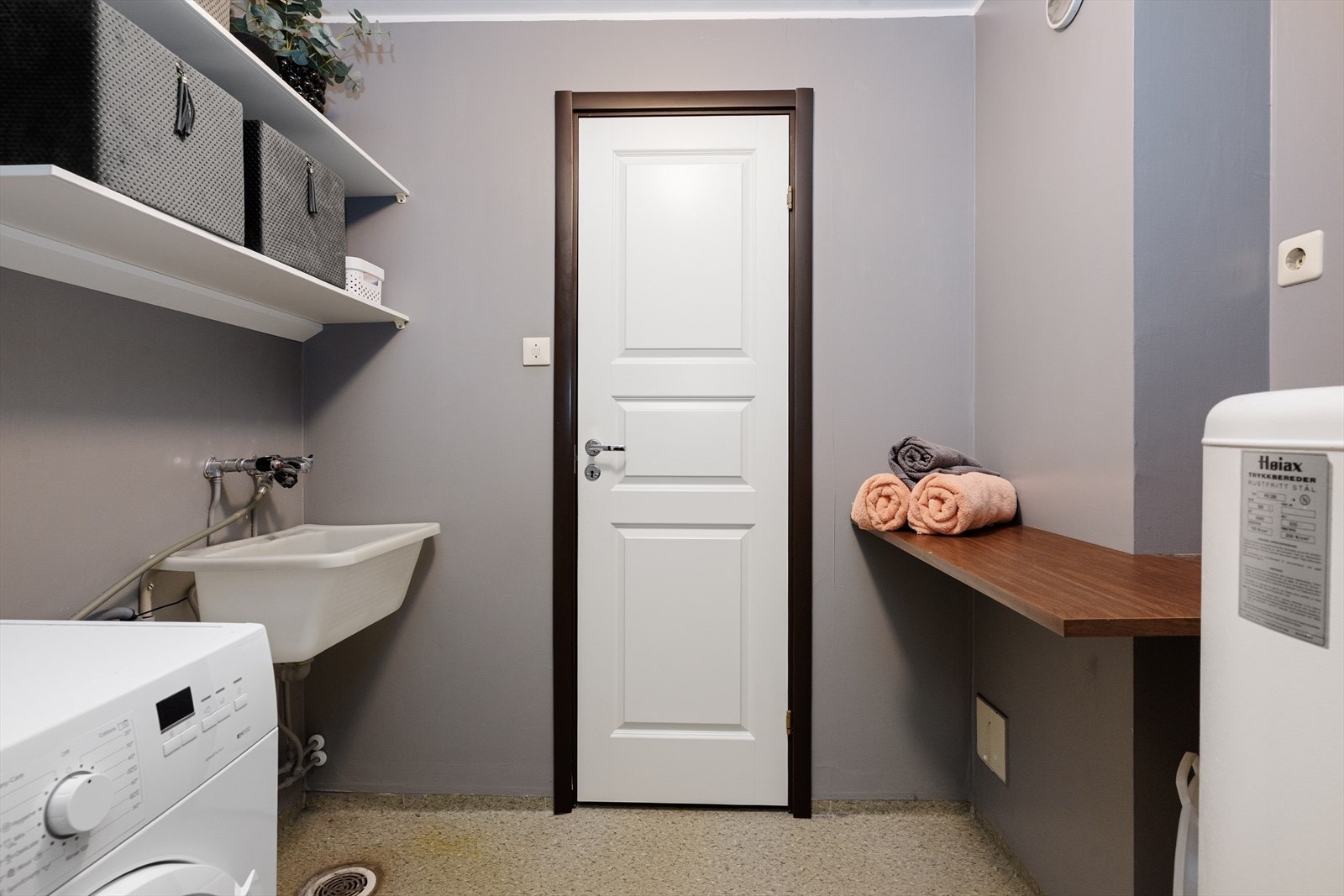 Romslig vaskerom med standard fra byggeår. Her er det opplegg for vaskemaskin, vegghengt plastkum og eldre varmtvannstank. Galleribilde