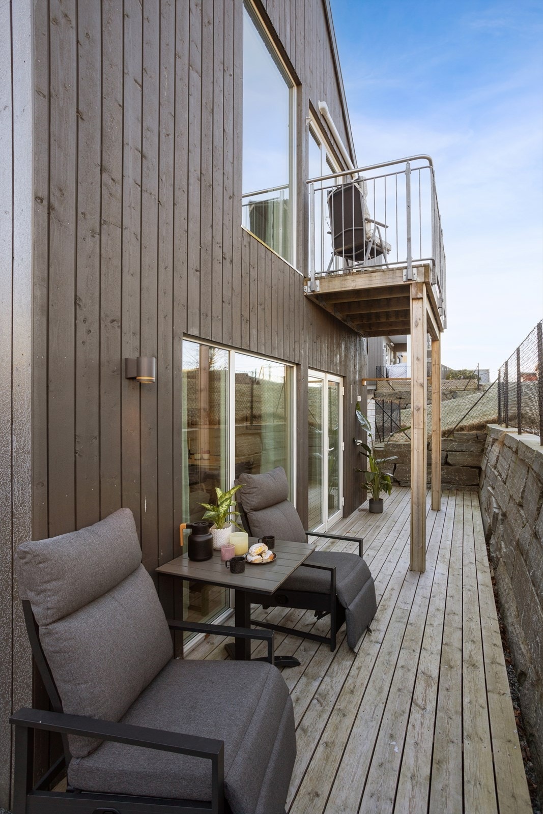 Uteplassen strekker seg langs boligens side og gir flere soner for utemøbler. Galleribilde