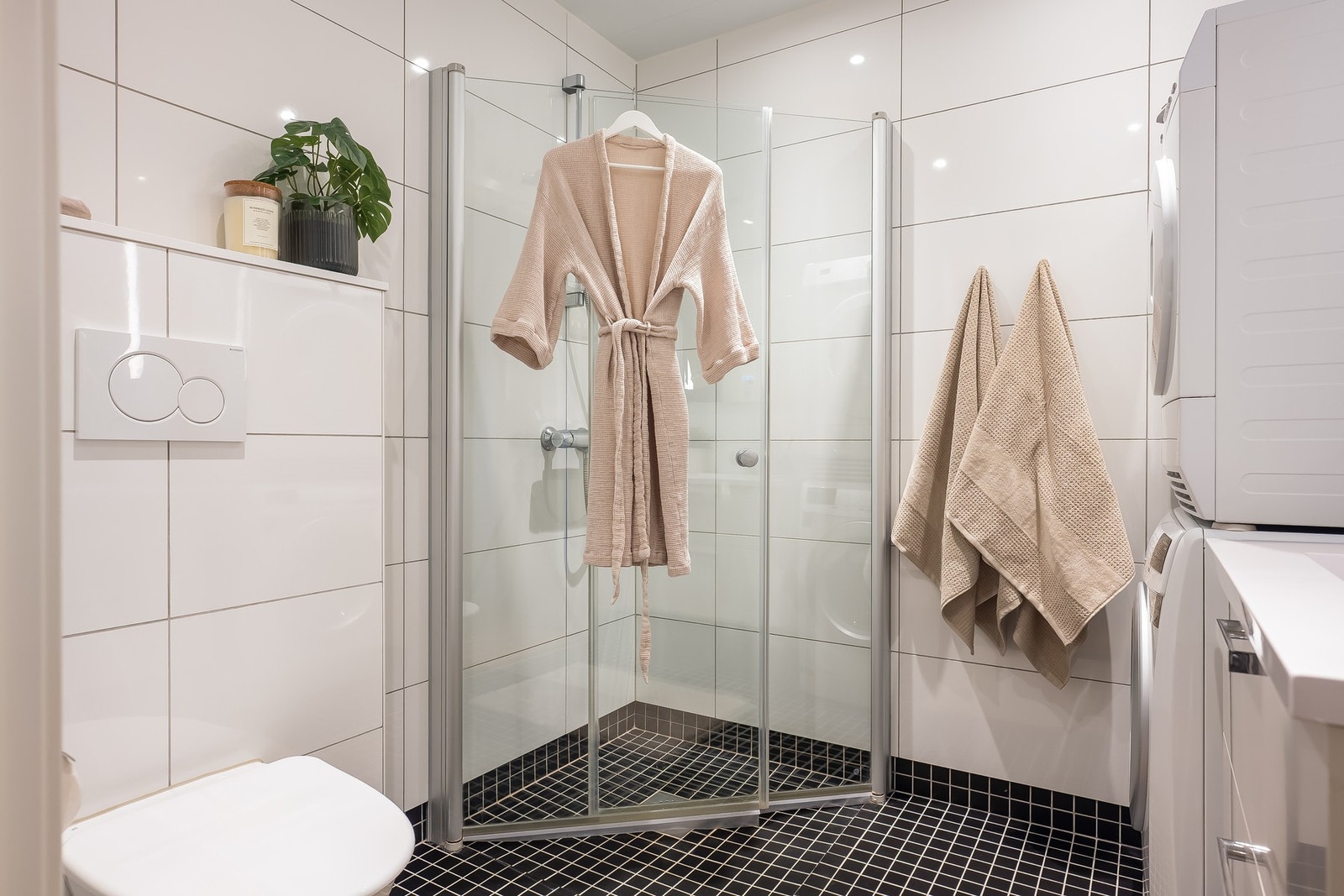 Badet består av dusjvegger av glass, innredning med servant, Opplegg for vaskemaskin (Kran og avløp), Vegghengt
toalett Galleribilde