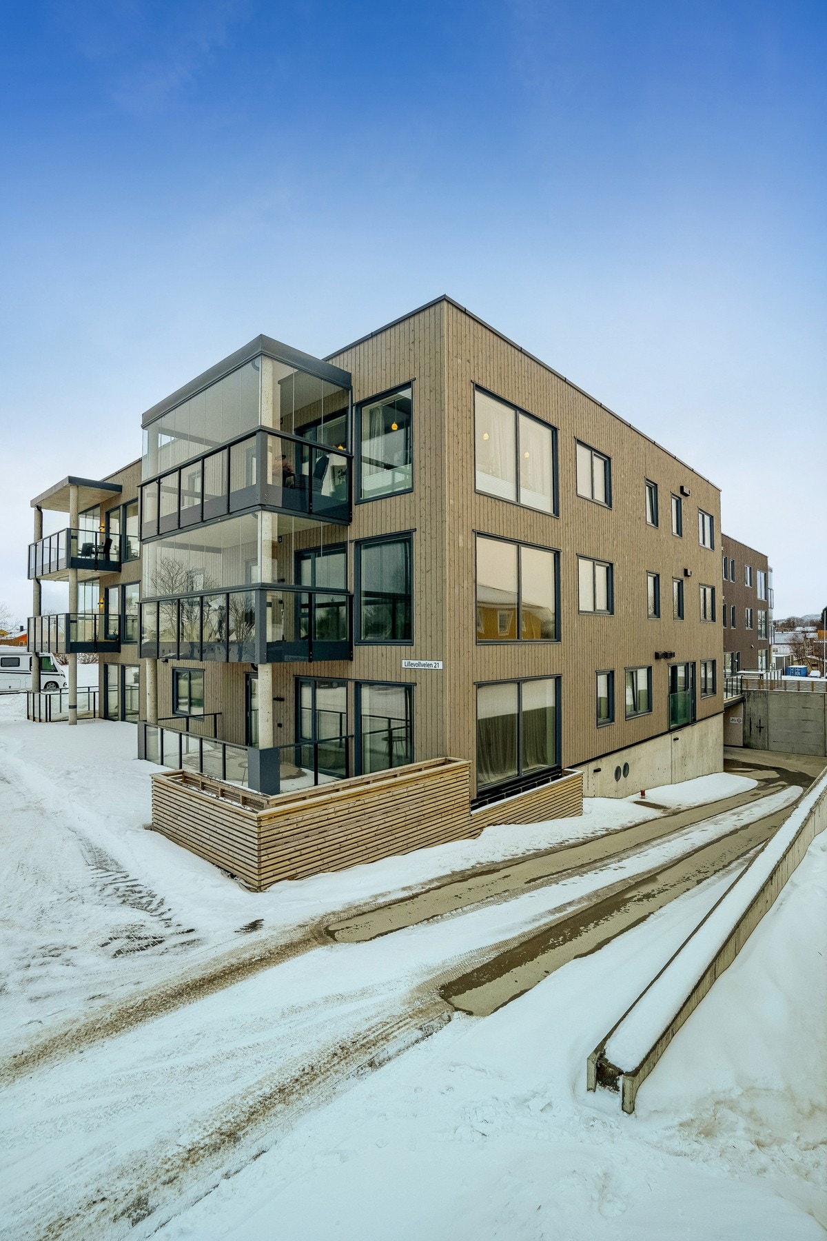 Asfaltert gjeste-parkering utenfor samt nedkjøring til garasjeanlegg. Galleribilde