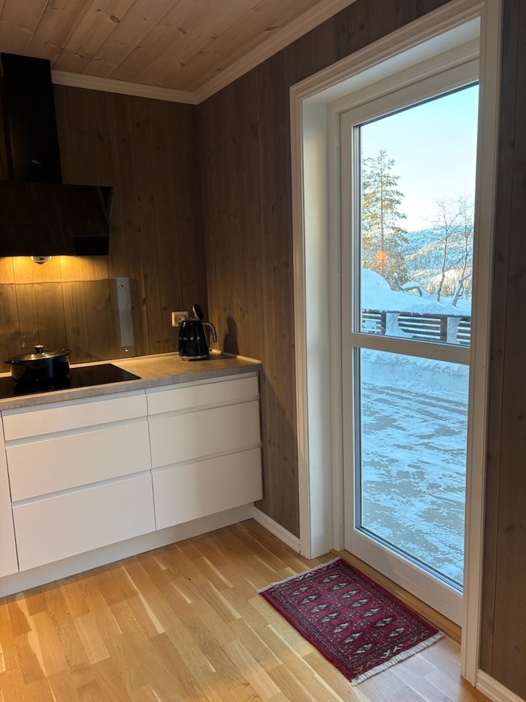 Selgers bilde. Fra kjøkkenet har man utgang til betongplatting og uteområdet. Galleribilde