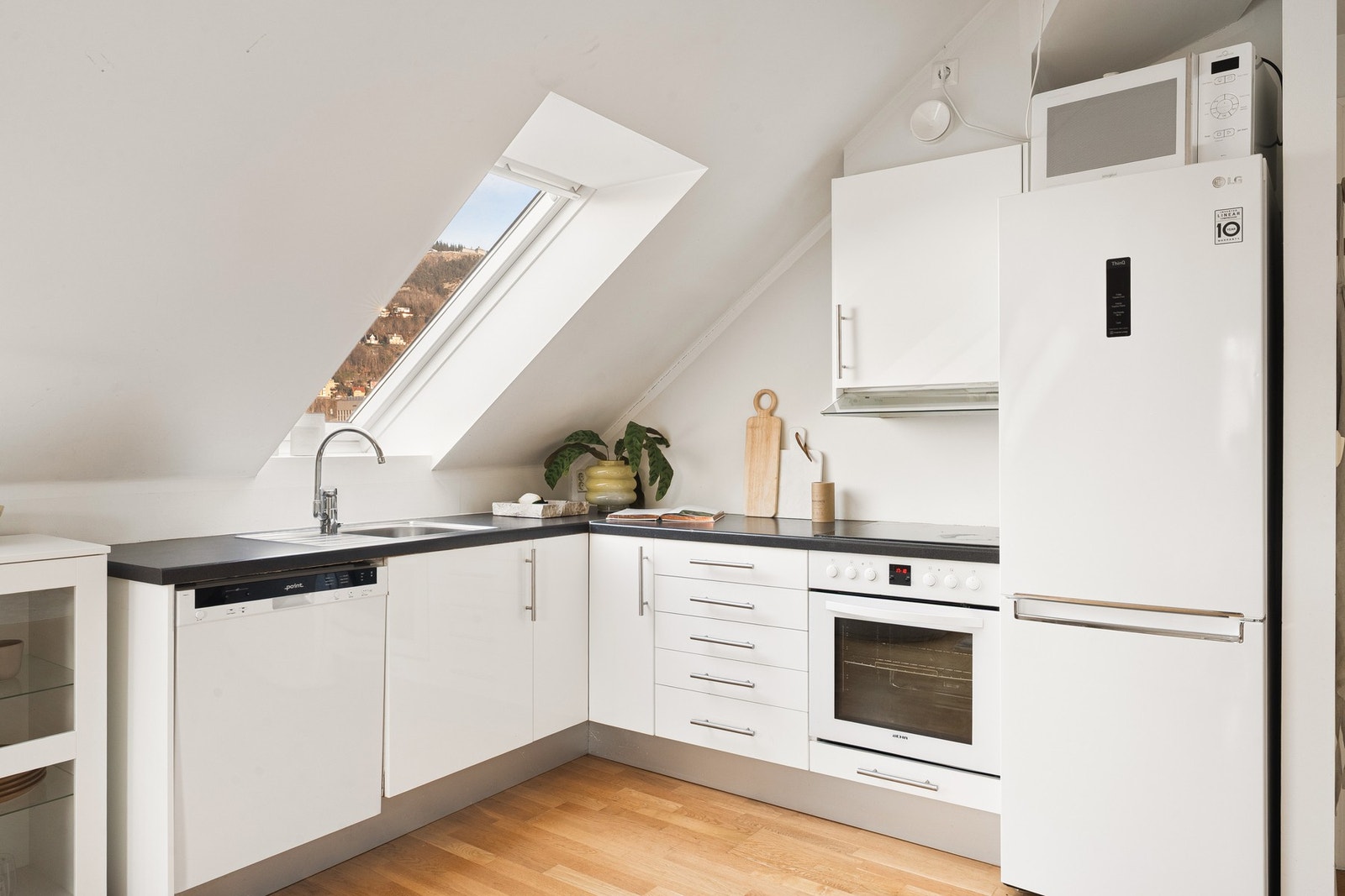 Kjøkkeninnredningen fremstår med slette fronter og laminat benkeplate. Galleribilde