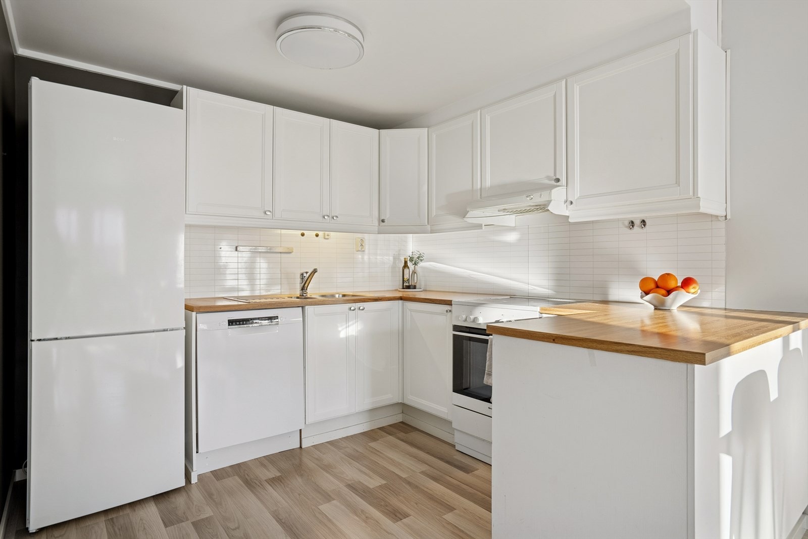 Kjøkkenet er utstyrt med komfyr, oppvaskmaskin og kjøleskap, og har en funksjonell utforming som dekker hverdagens behov Galleribilde