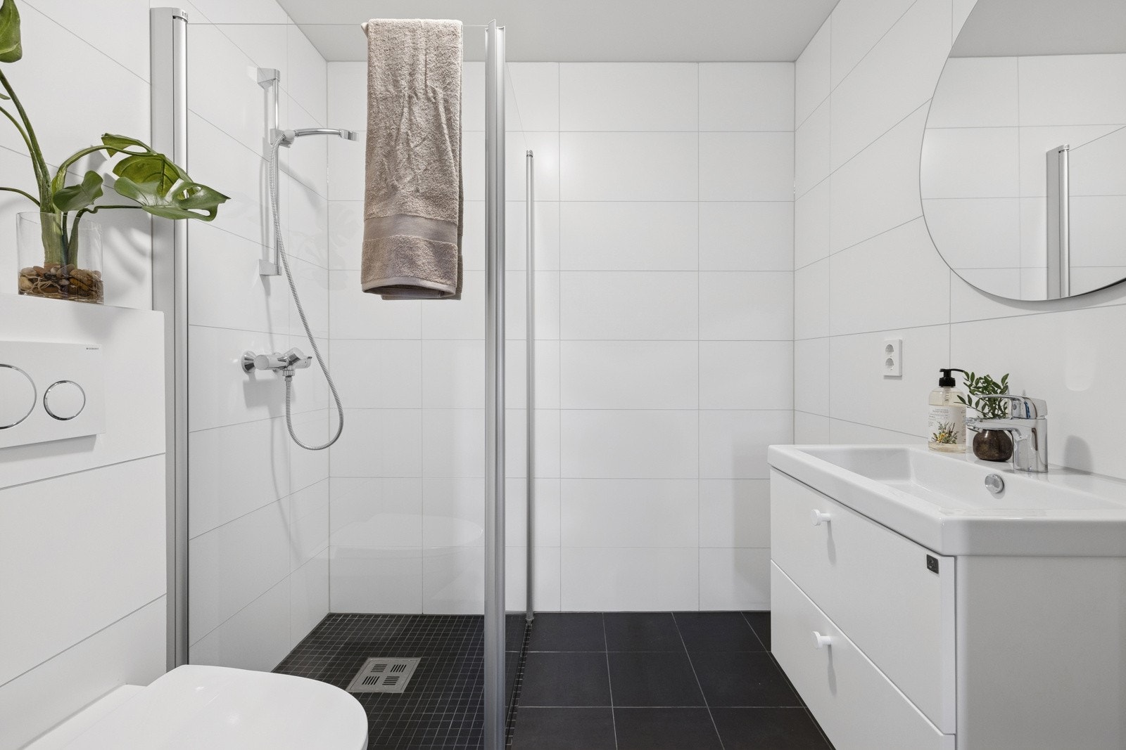 U. etasje: Tiltalende flislagt bad med varmekabler. Vegghengt klosett, dusjhjørne med innfellbare dusjvegger samt baderomsinnredning og speil Galleribilde