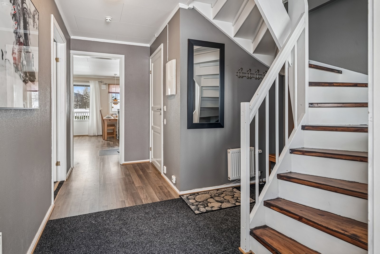 Den innvendige tretrappen med lakkerte trinn forbinder leilighetens to plan. Galleribilde