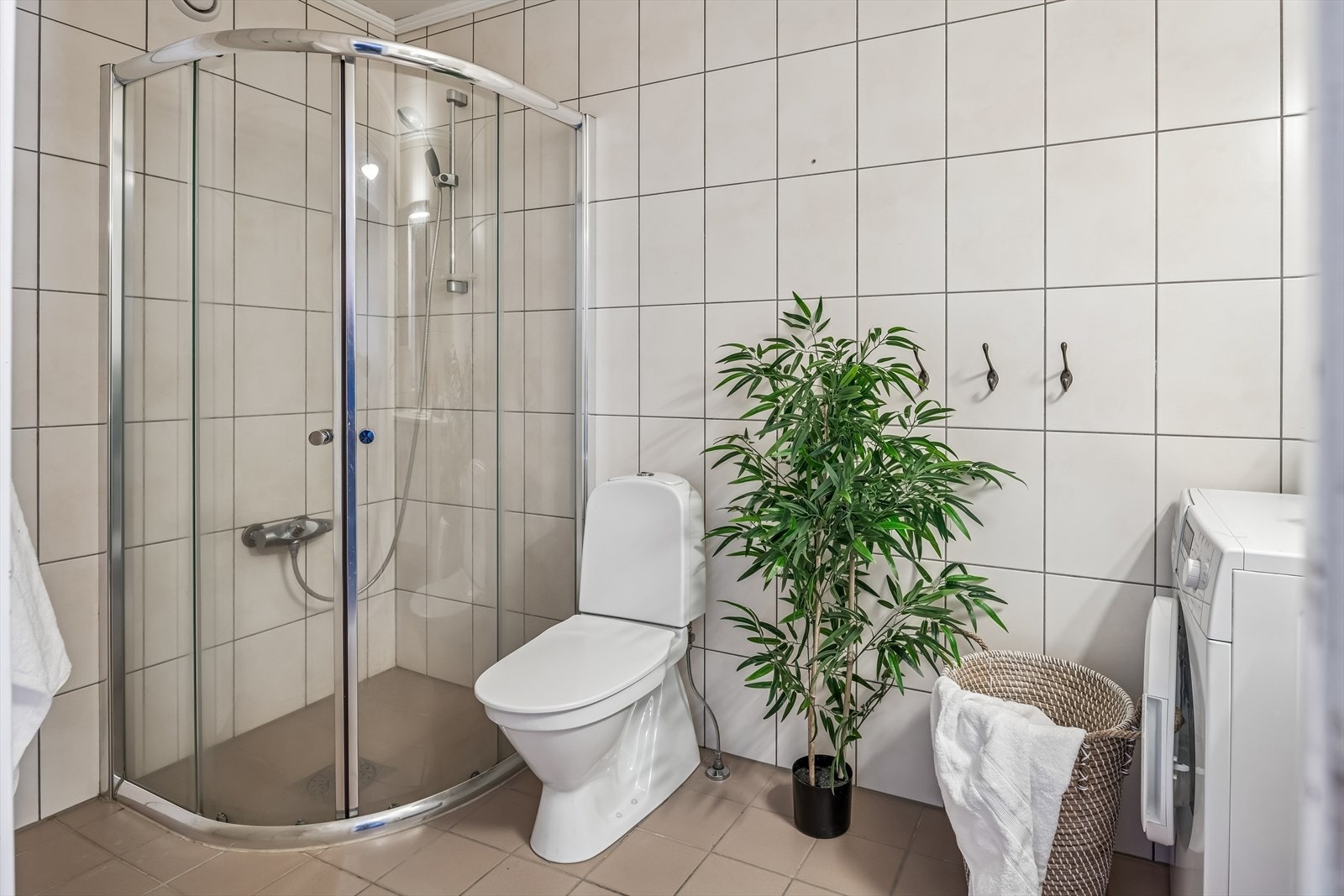 Her er det elektrisk gulvvarme for økt komfort, samt et dusjhjørne med glassdører. Galleribilde