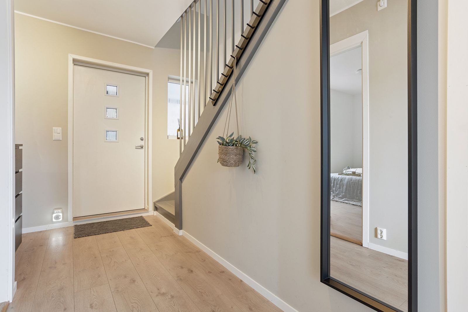 Entréen har en ytterdør med glatt finer fra 2016 og en heltre trapp som leder opp til loftsetasjen. Galleribilde