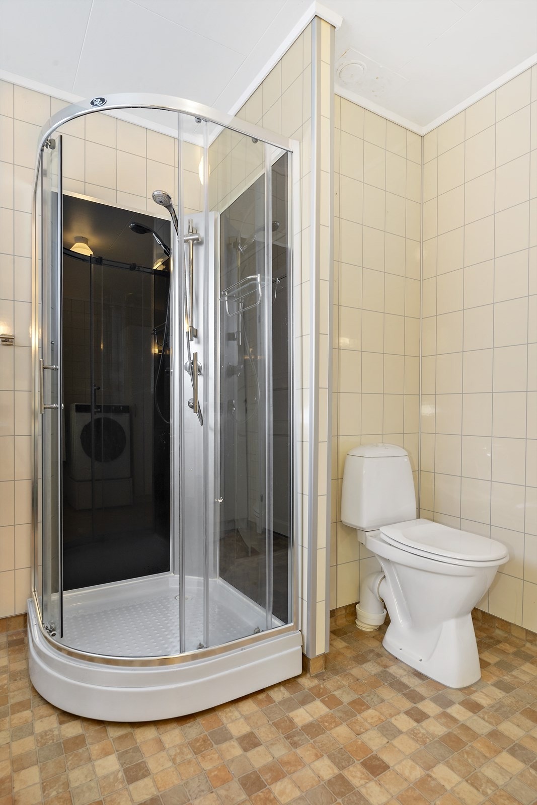 Dusjkabinett og gulvmontert toalett gir funksjonell innredning på badet. Galleribilde