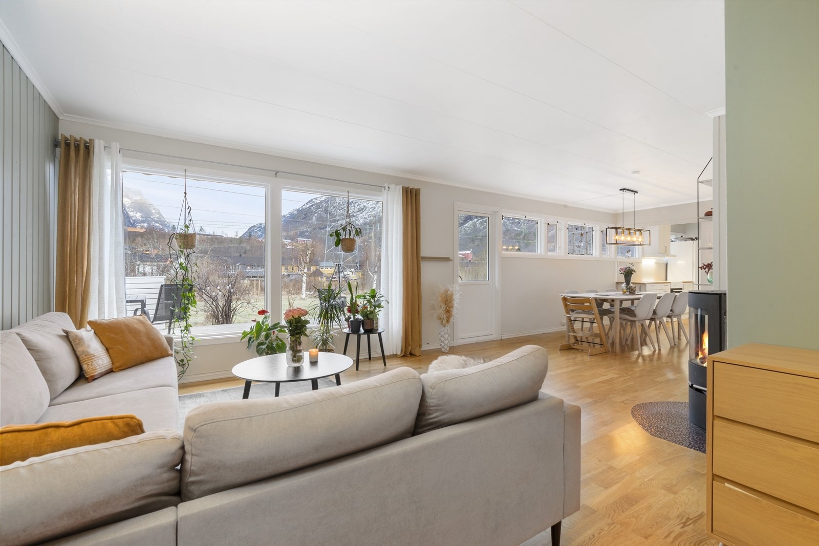 Store vindusflater gir utsyn mot hagen fra stuen, og mellom stue og spisestue har man dør til markterrasse. Galleribilde