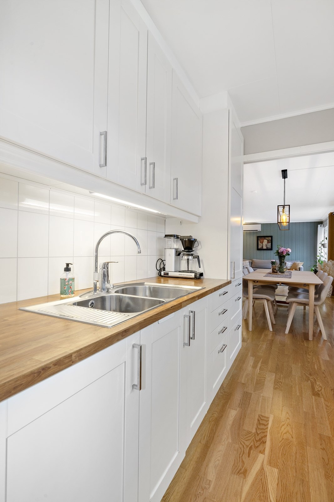 Tidløs og ren kjøkkeninnredning med hvite fronter og integrerte oppvaskmaskin. Galleribilde