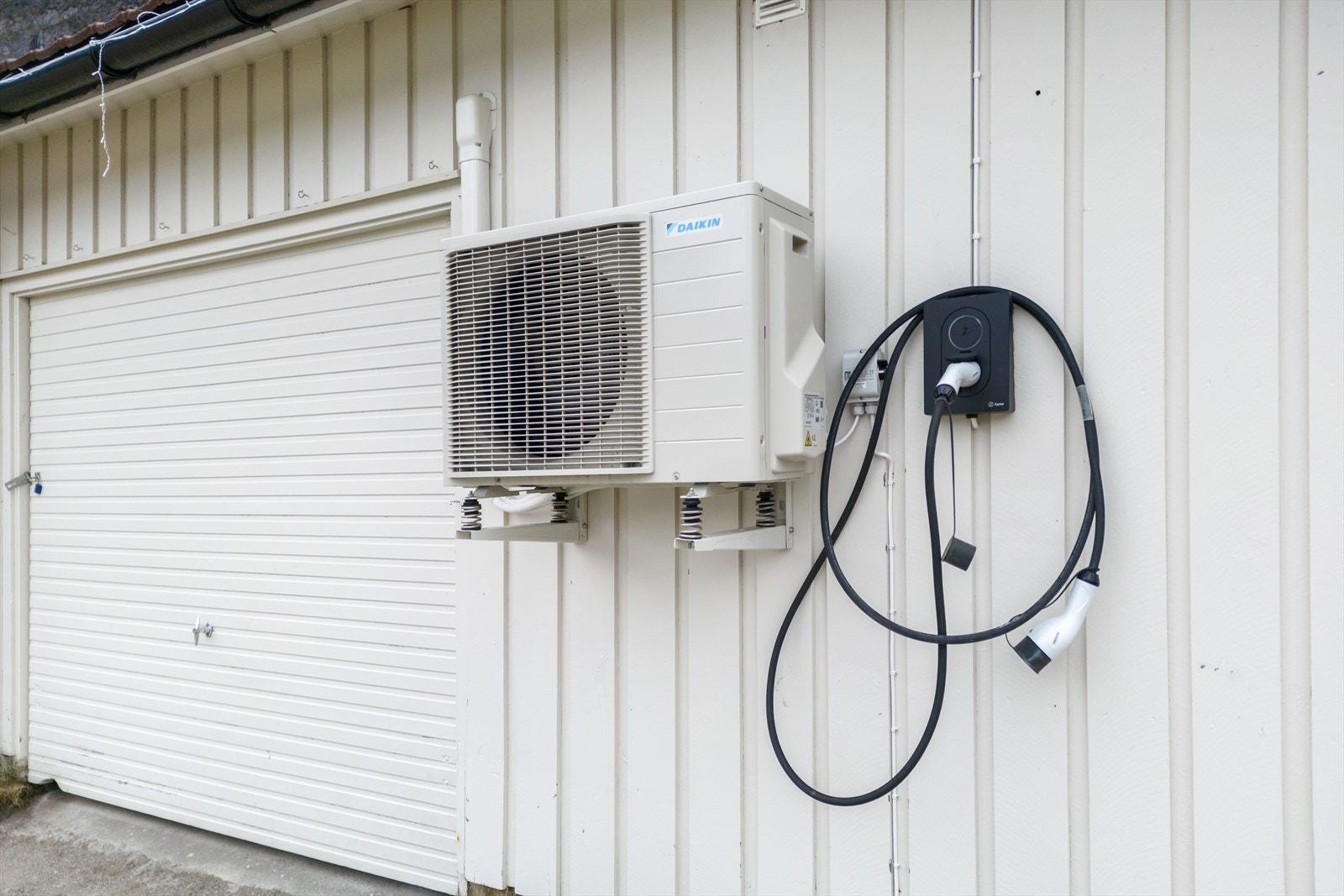 Ladekabel til bil er montert på husveggen. Galleribilde