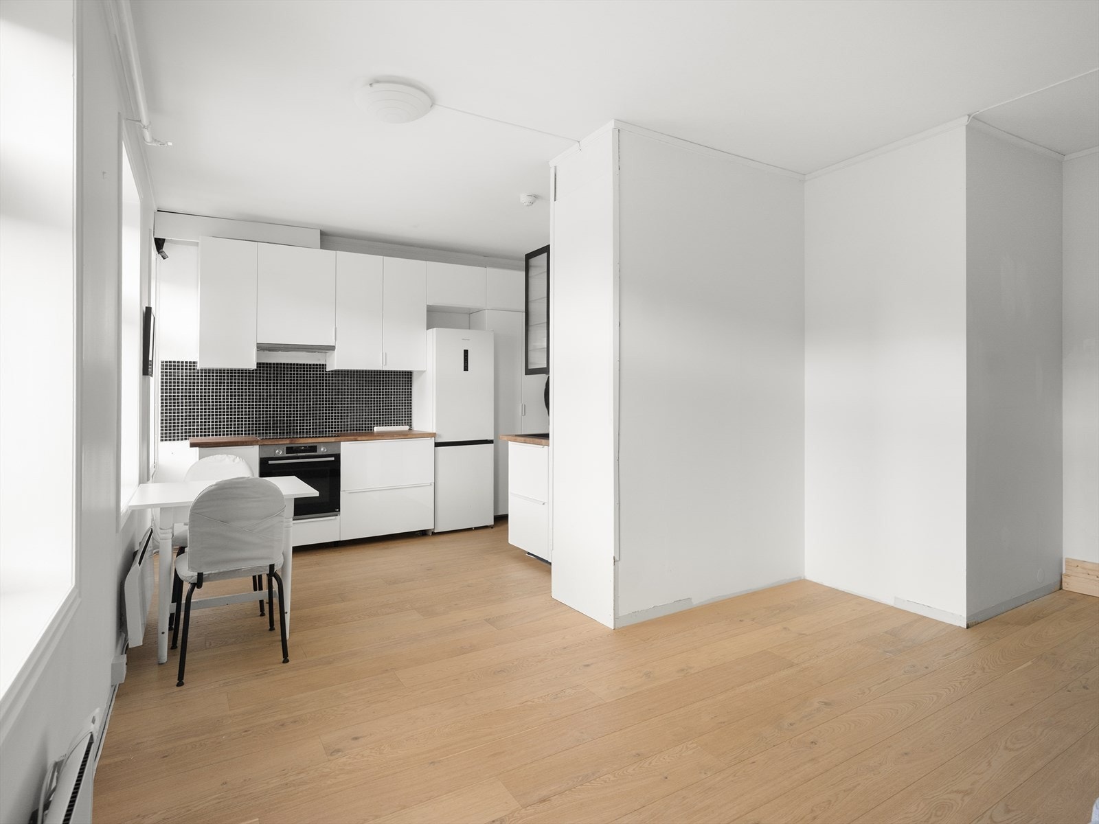 Når man kommer inn i leiligheten blir man møtt av en åpen stue- og kjøkkenløsning som måler til sammen 23 kvm. Galleribilde