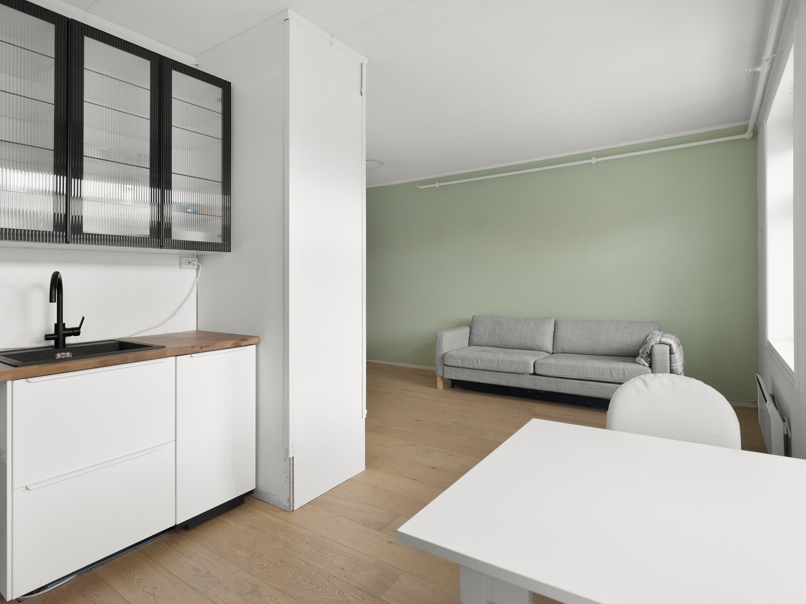 Den praktiske og åpne løsningen gir plass til egen sofa og spisegruppe. Galleribilde