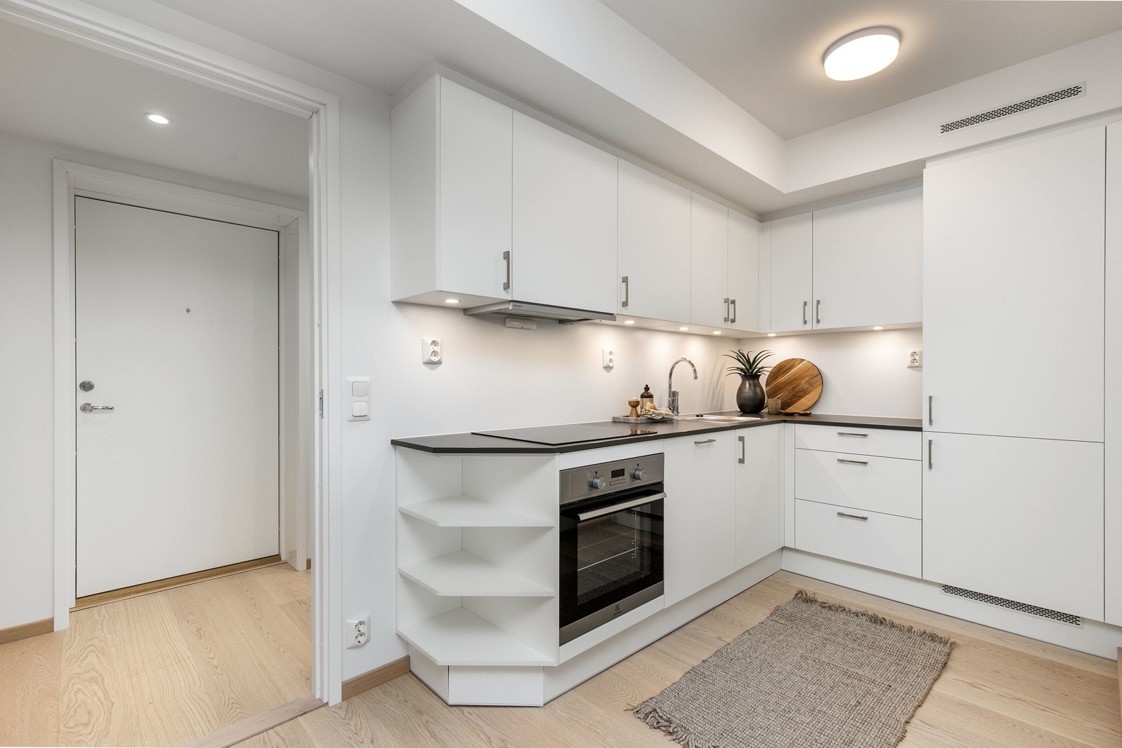 Lekkert kjøkken i åpen løsning mot stuen, med integrerte hvitevarer. Galleribilde