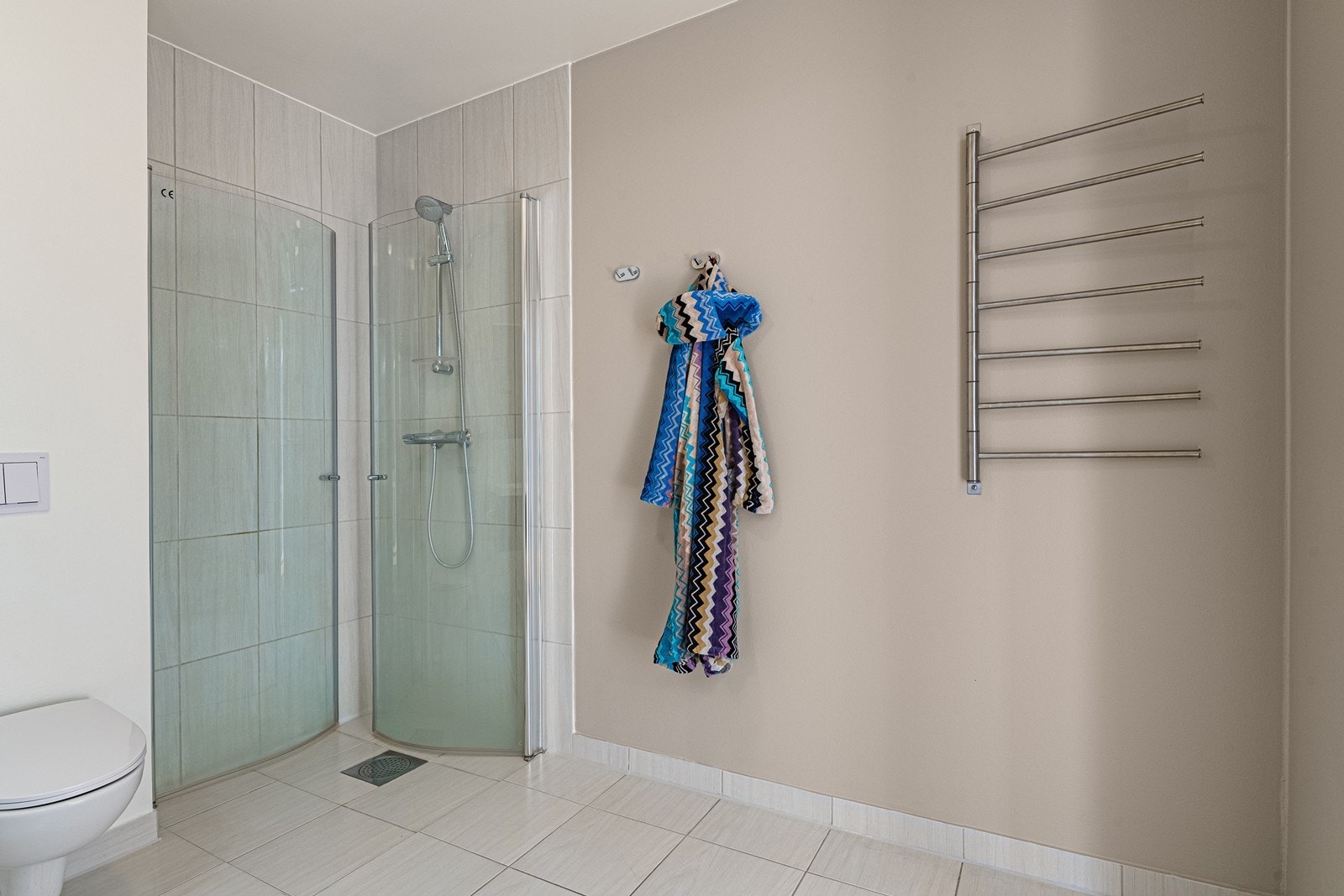 Innfellbare dusjdører og praktisk oppheng til klær og håndkle. Galleribilde