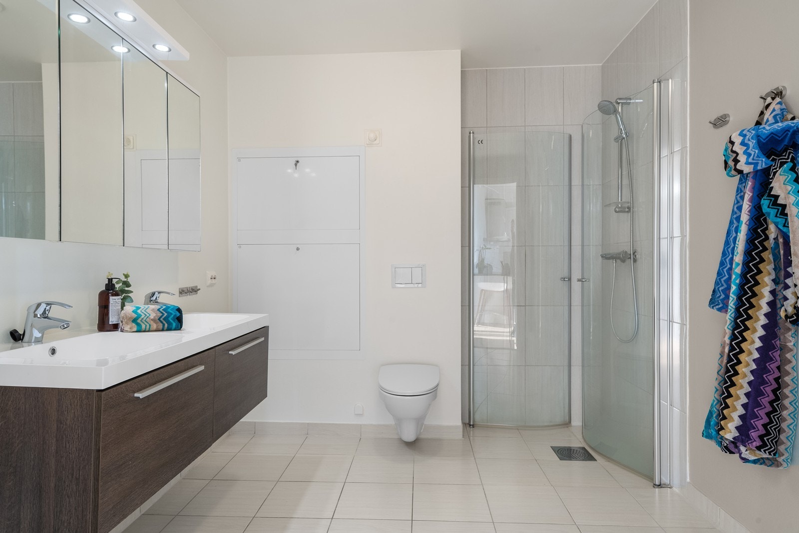 Tidløst bad med fliser på gulv og i dusj. Malte veggflater som gjør det lett å bytte stil uten store investeringer. Galleribilde