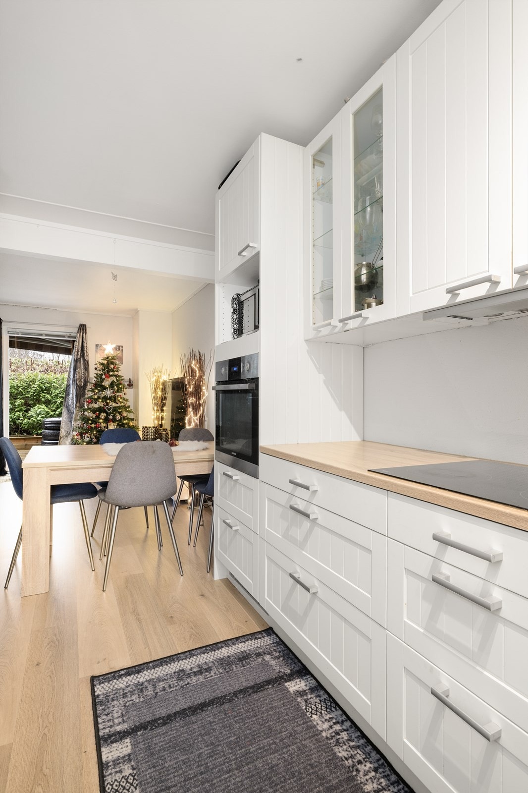 Laminerte benkeplater med nedfelt induksjonstopp og oppvaskkum i rustfritt stål. Over kokesonen er det ventilator med avtrekk ut. Galleribilde