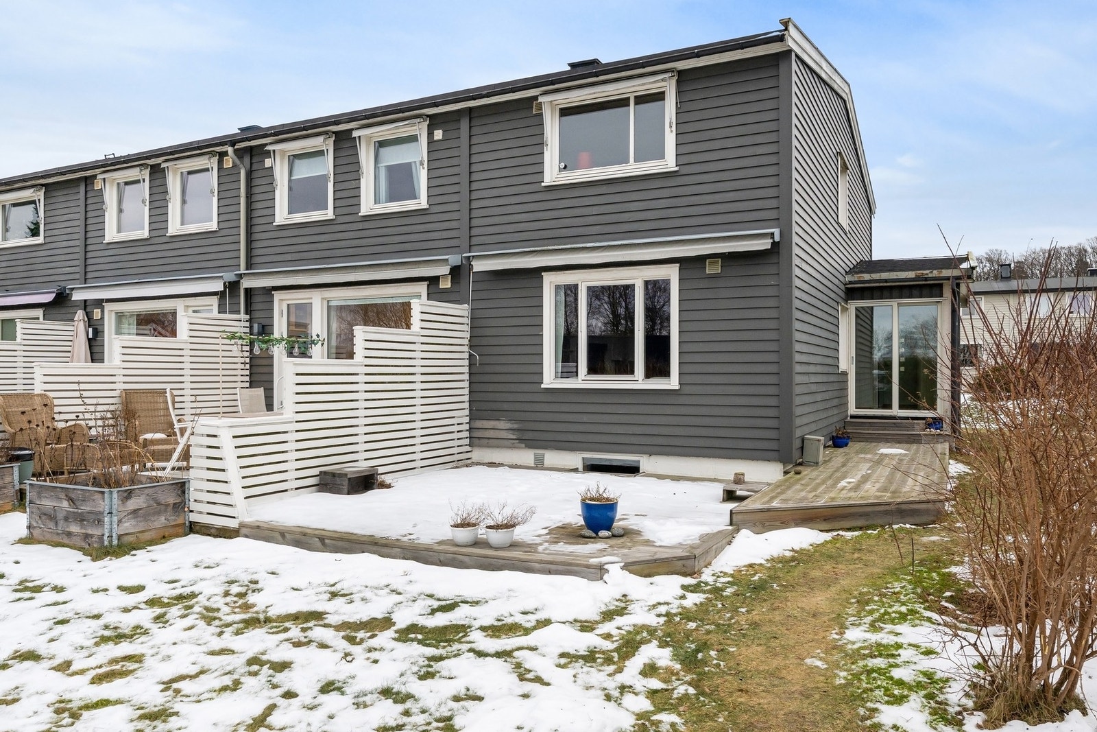 Terrassen strekker seg rundt deler av boligen, med god plass dekket bord og hyggelige middager Galleribilde