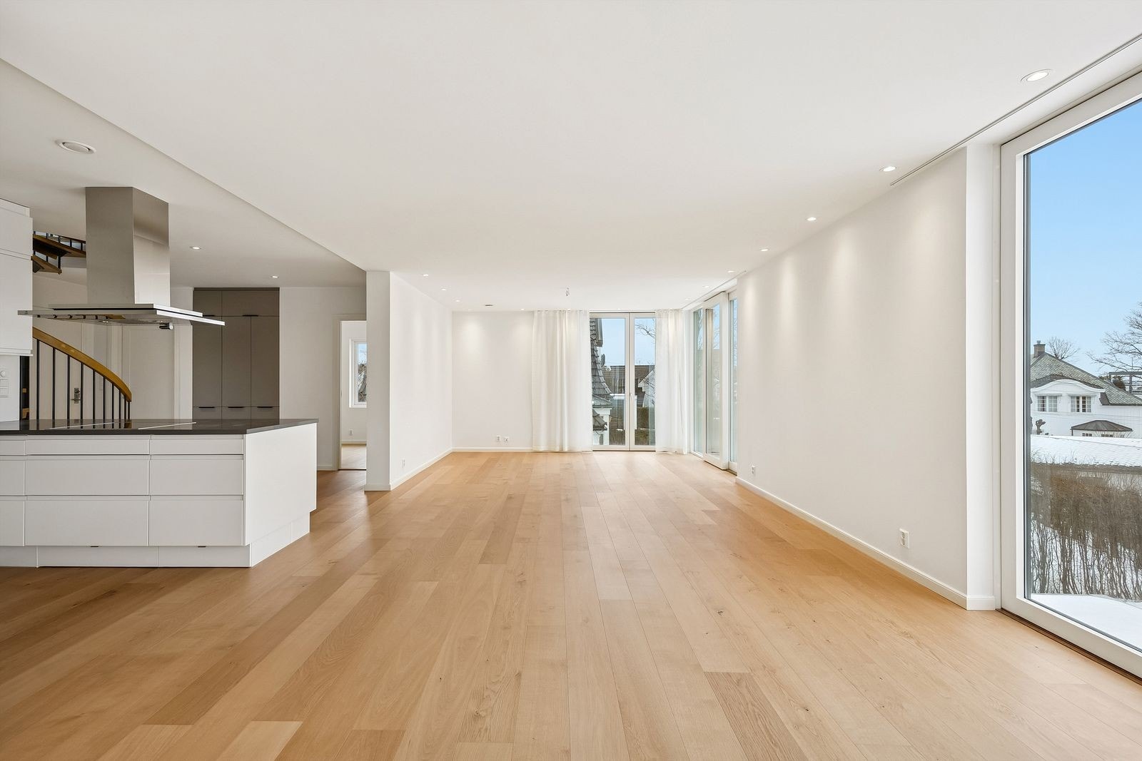 Åpen stue og kjøkkenløsning med store vinduer fra gulv til tak Galleribilde