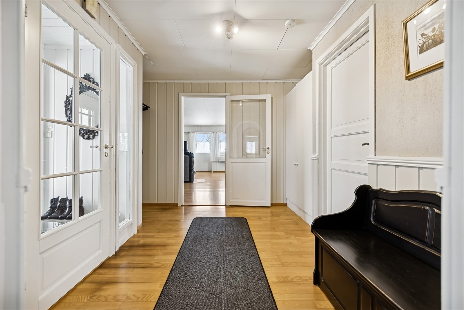 En sentral gang med parkett på gulvet knytter rommene i etasjen sammen på en god måte. Galleribilde