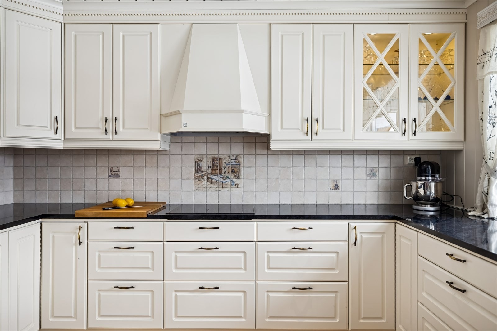 Detaljer som vitrineskap, belysning og fliser over den laminerte benkeplaten. Galleribilde