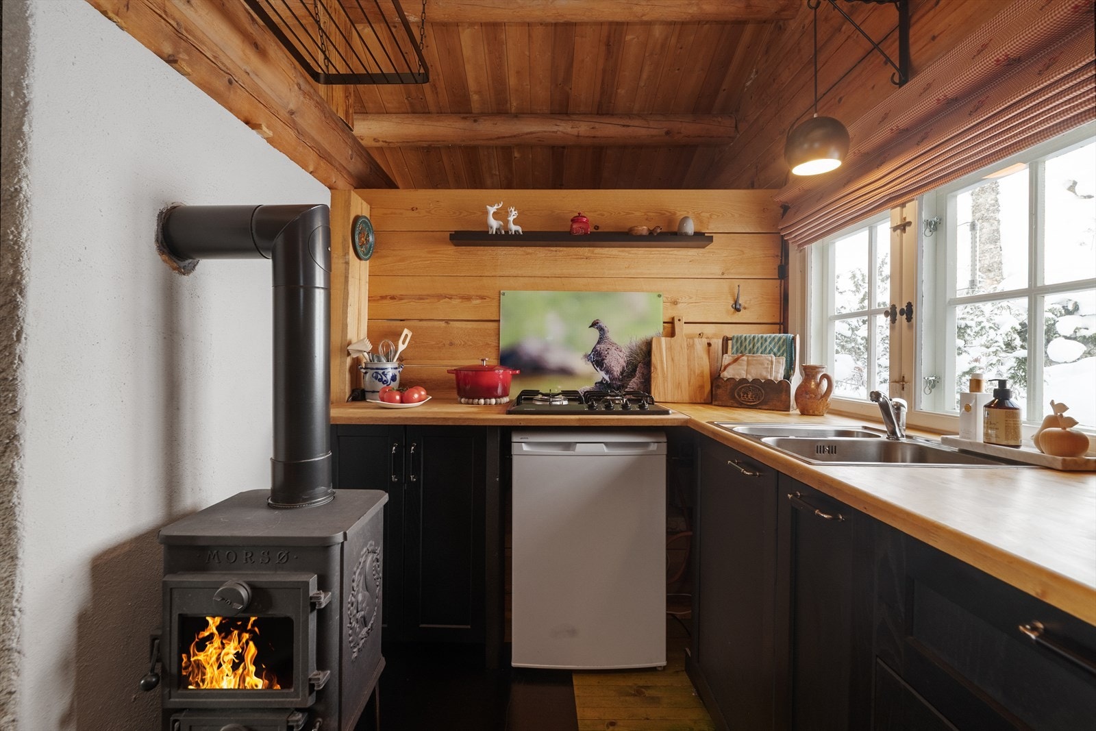 På kjøkkenet er det også etablert ildsted, med vedovn type Morsø montert i 2025. Hvitevarer medfølger ved salg. Innlagt vann til kjøkken er ikke søkt om eller godkjent. Galleribilde