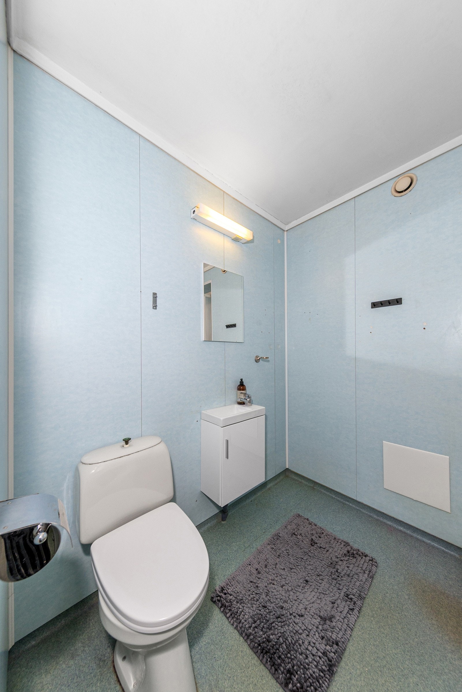 Bad med dusjkabinett, gulvstående toalett og opplegg til vaskamaskin. Galleribilde