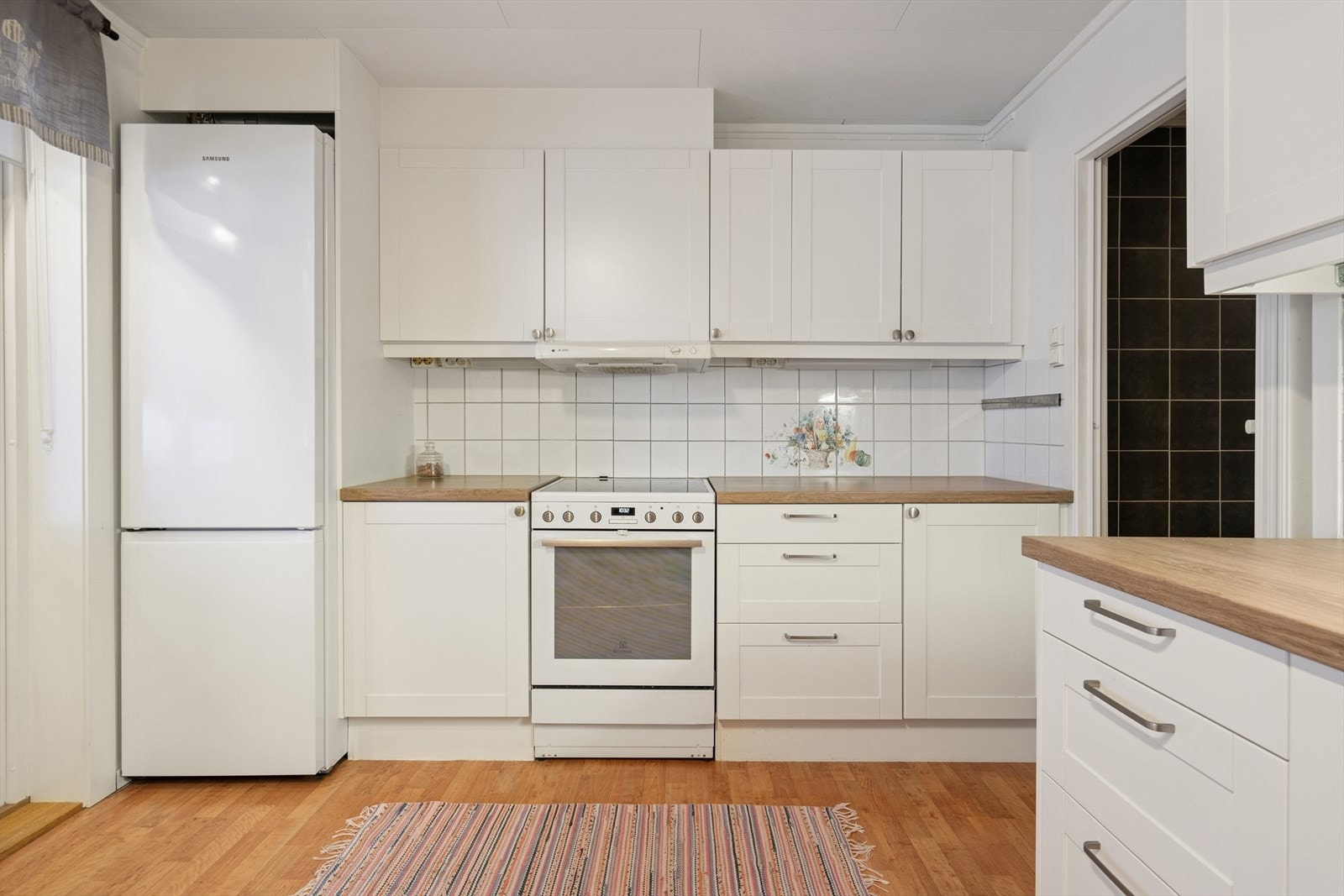 Kjøkkenet har rikelig med skap og benkeplass Galleribilde