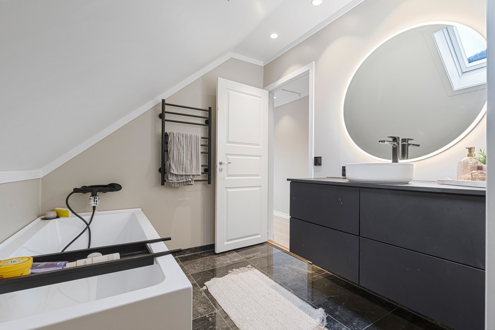 Bad på loft har flislagt gulv med sokkelflis og er utstyrt med baderomsinnredning, vegghengt wc, flislagt dusjnisje og badekar Galleribilde