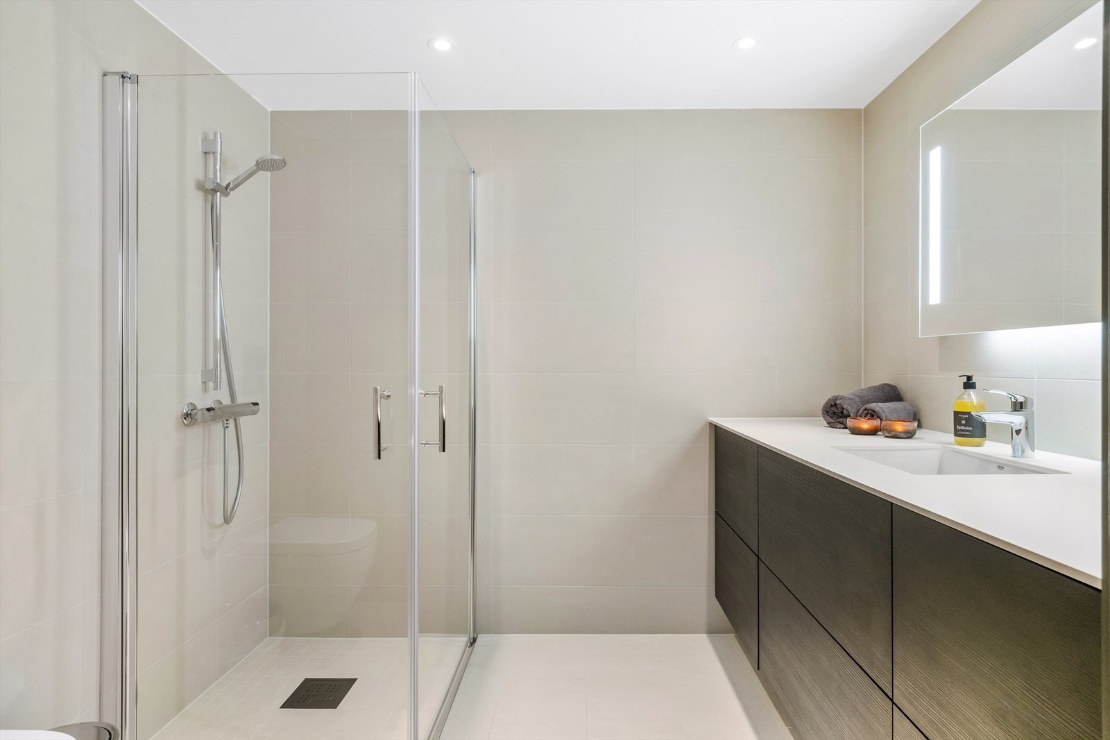 Lekkert heilflisa bad med downlights i himling og varmekablar i golv. Galleribilde