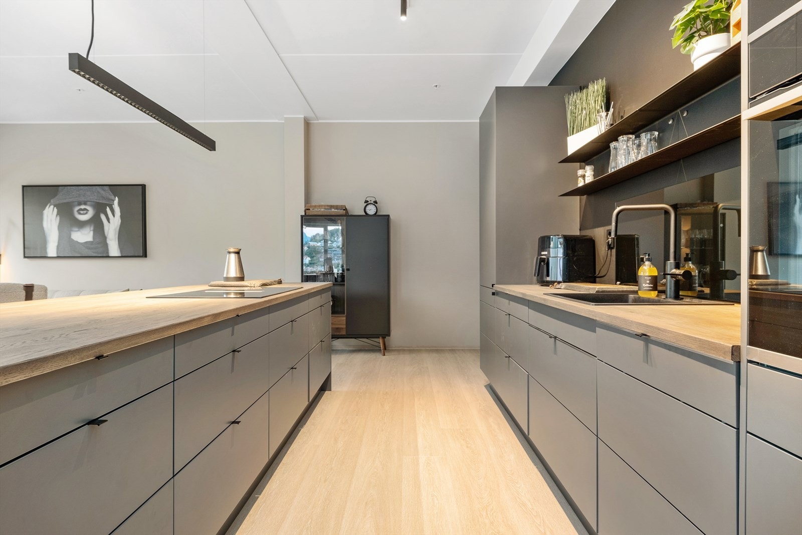 Slette mørkegrå frontar med benkeplate i mørk heiltre. Svært god skuffe- og benkeplass. Galleribilde