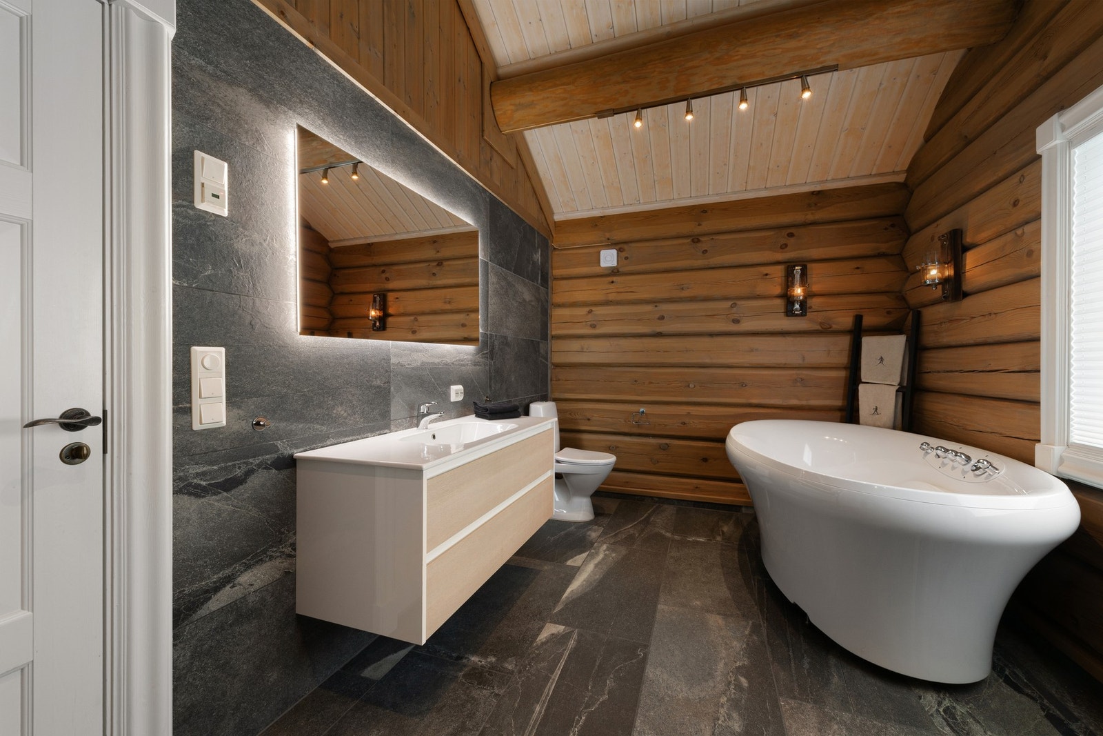 Badet er innredet med dusj, toalett, servant med innredning og et stilig boblebad. Galleribilde