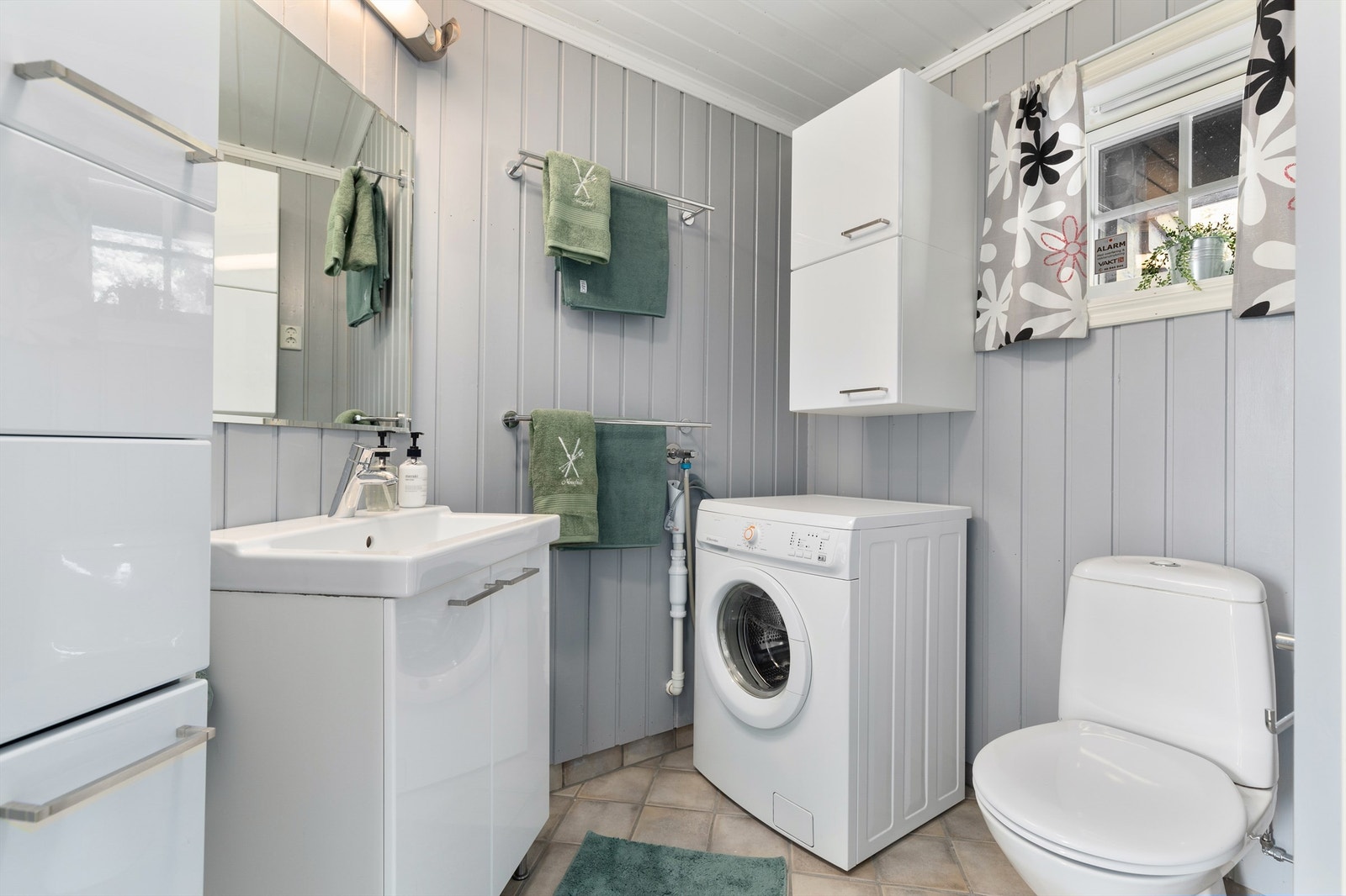 Pent bad med flislagt gulv med varme. Badet har opplegg for vaskemaskin Galleribilde