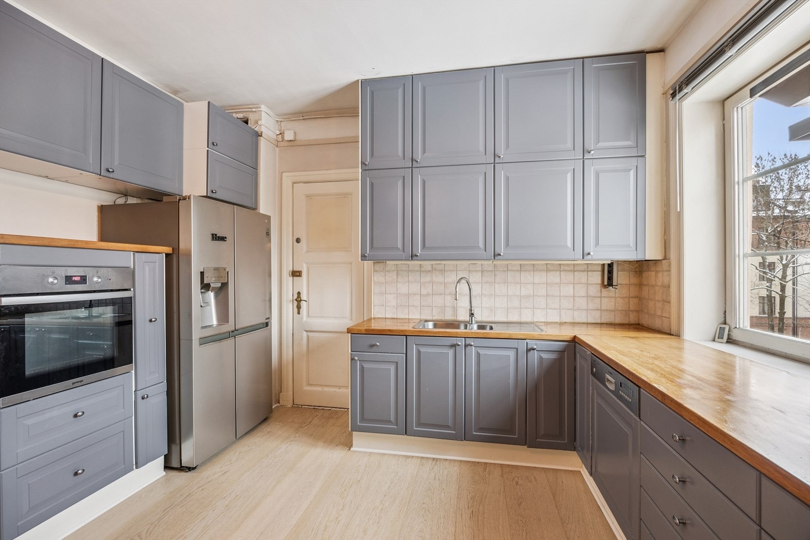 Bilde av kjøkken med spiseplass og kjøkkeninnredning m/nedfelt induksjon stopp, integrert oppvaskmaskin og stekeovn. Løst side by side kjøl/frys i egen nisje. Galleribilde