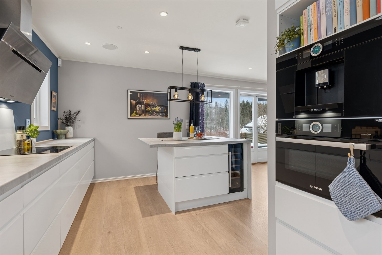 Kjøkkenøyen er blant annet utstyrt med et integrert vinskap, og nedfelte stikkontakter i benkeplaten. Galleribilde