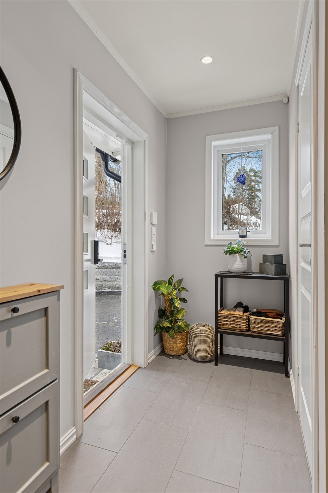 Man ønskes velkommen inn i en lys og romslig entré med flislagt gulv. Galleribilde