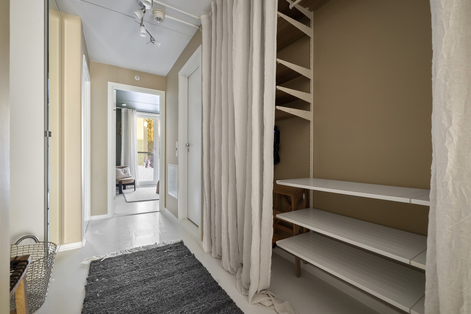 Svært god lagringsplass i vegghengt hyllesystem skjermet med gardin Galleribilde