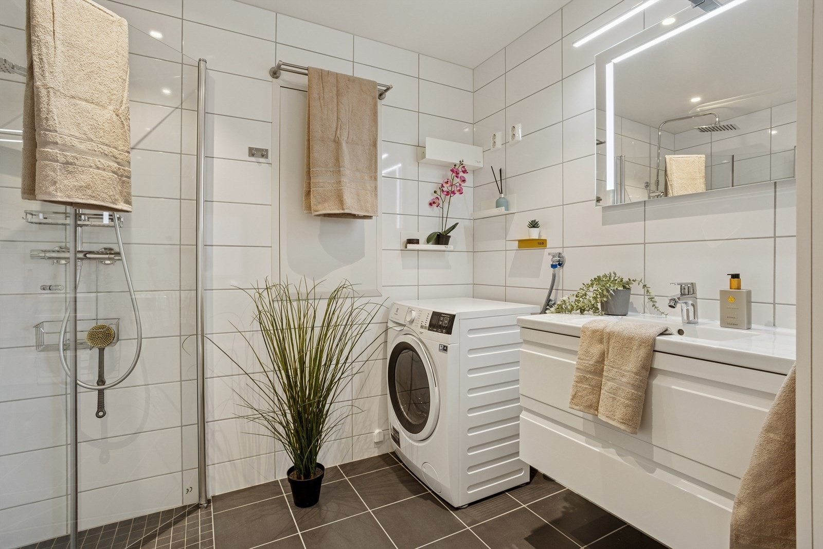 Helfliset bad fra 2021 med vegghengt toalett, dusj med glassdør og servantmøblement. Galleribilde