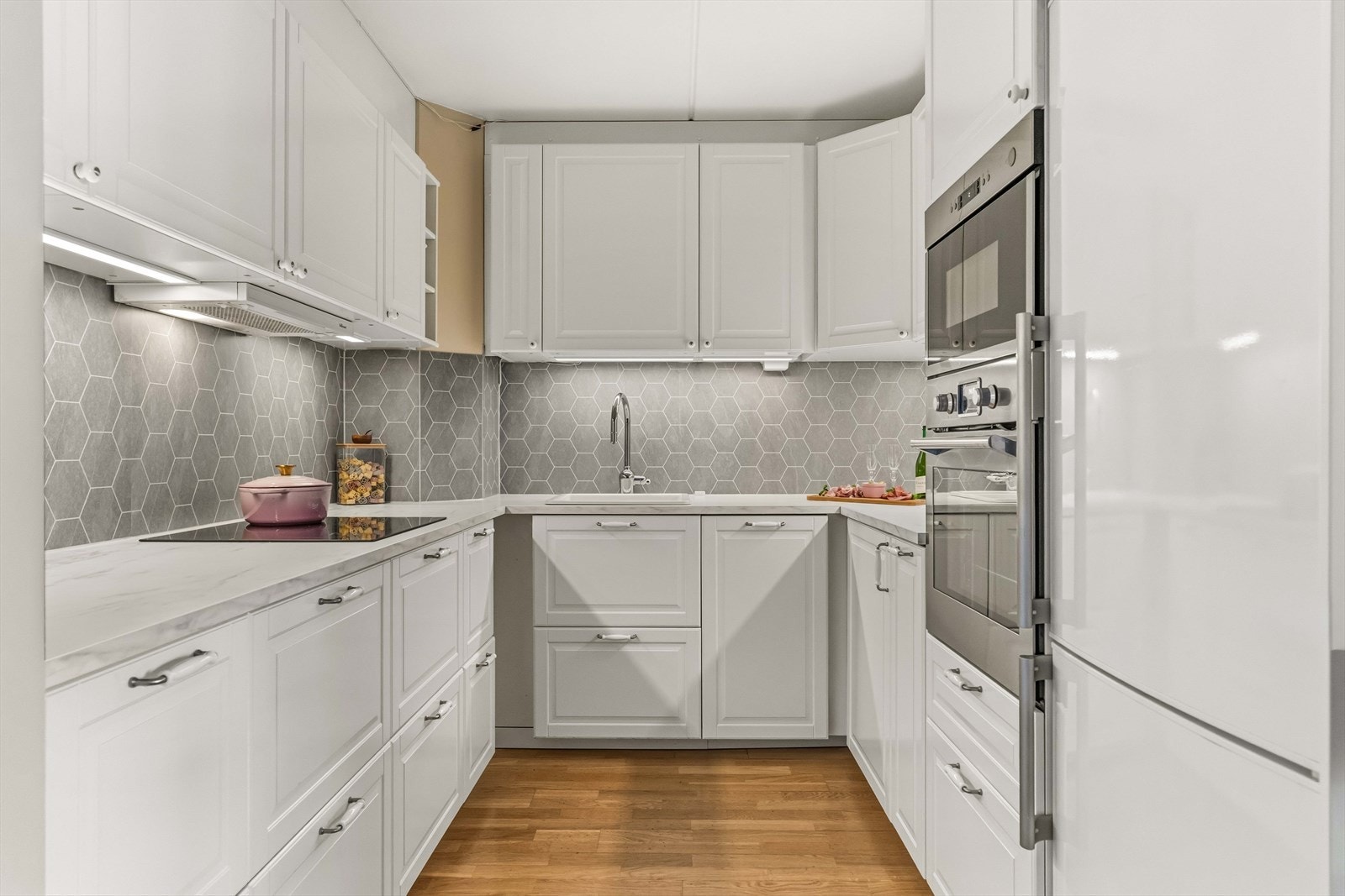 Kjøkkenet har opplegg for integrert oppvaskmaskin (smal variant), ettgreps kran, platetopp, stekeovn, mikrobølgeovn og frittstående kjøl/fryseskap. Galleribilde