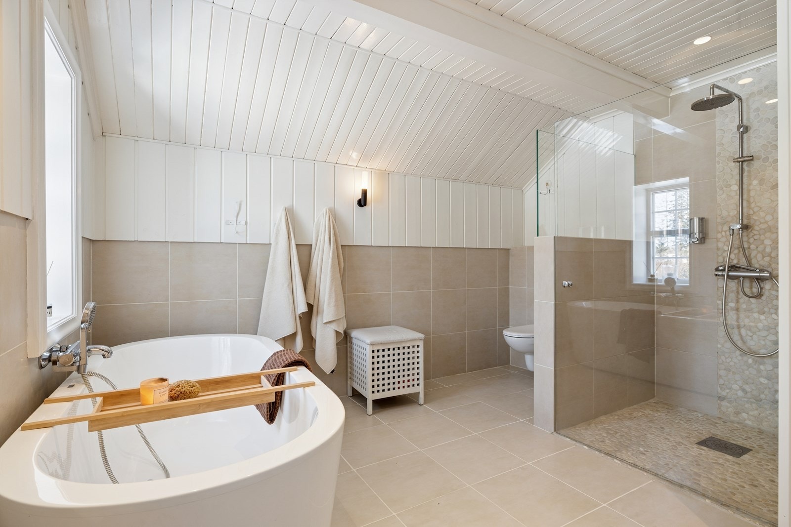 Frittstående badekar og vegghengt toalett. Galleribilde