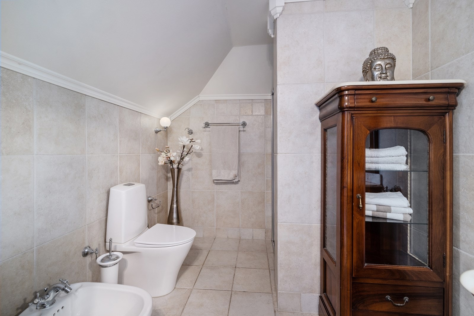 Badet er utstyrt med innredning med 2 nedfelte servanter, toalett, bidè og innfliset badekar i hjørne. Galleribilde