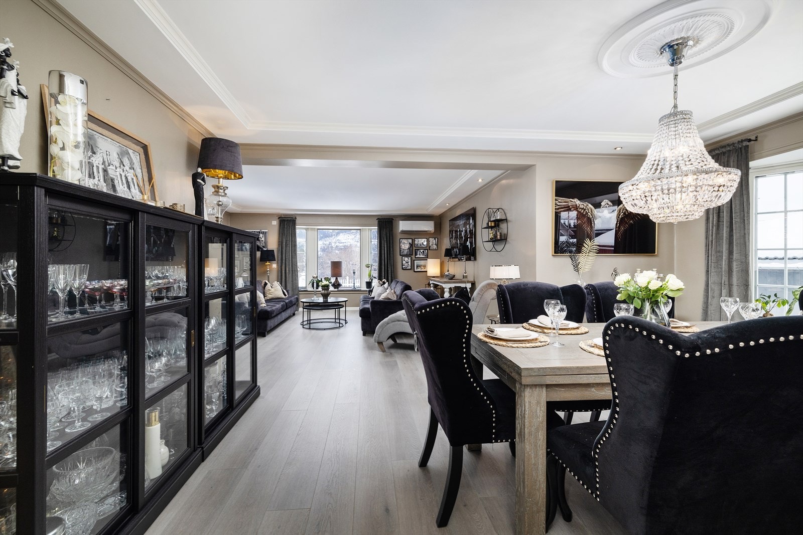 Stuen fremstår som et innbydende og sofistikert oppholdsrom med gjennomførte materialvalg og en harmonisk fargepalett på vegger og 1-stavs laminat på gulv. Galleribilde