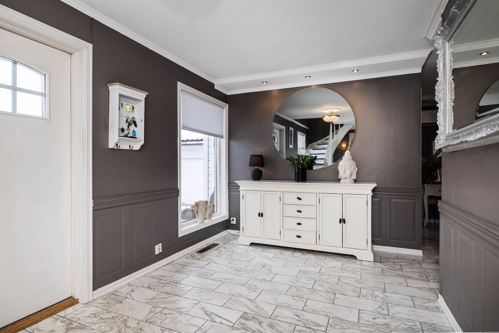 Flislagt, innbydende hall med god plass til oppbevaring av klær og sko i garderoberom. Galleribilde