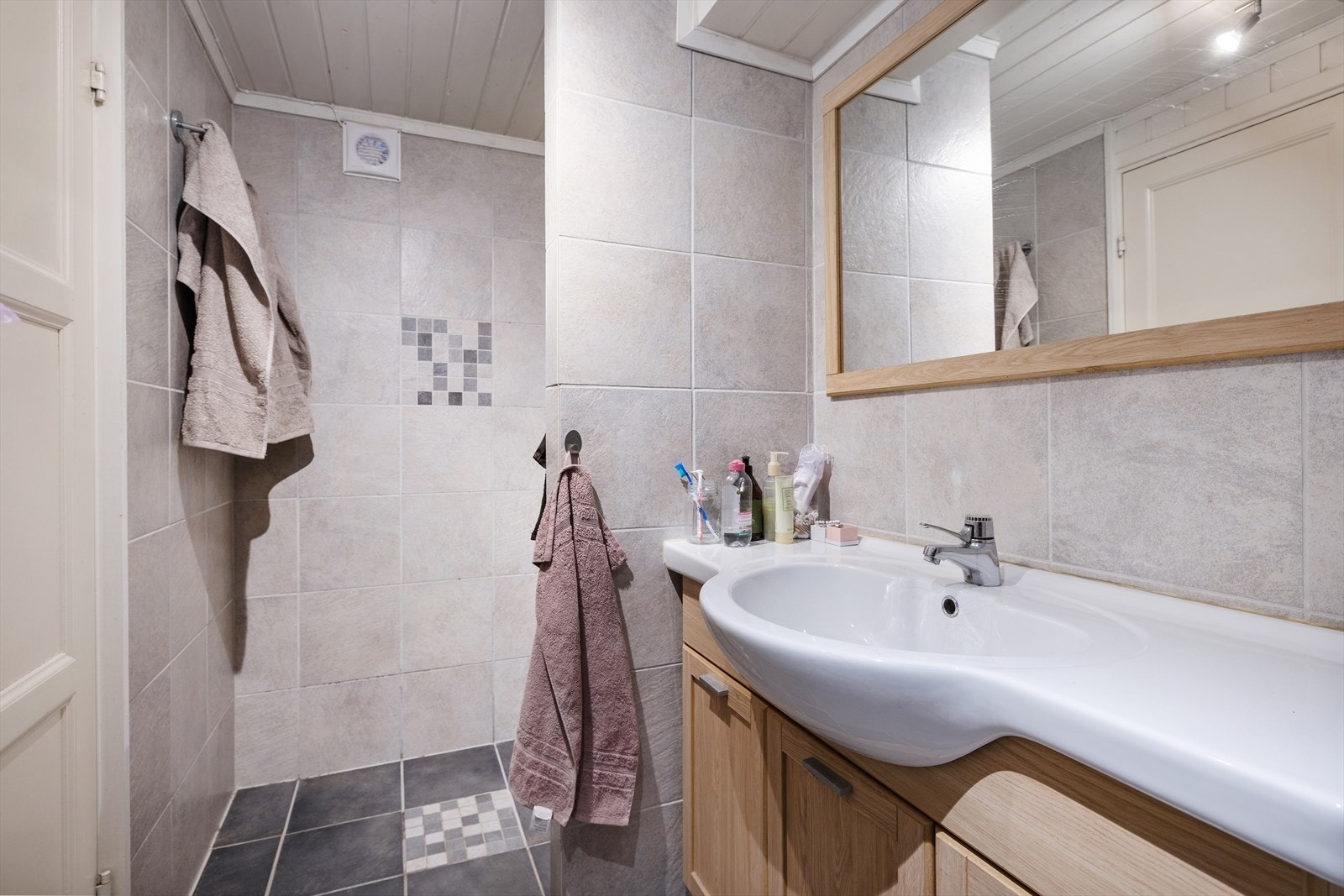 Flislagt bad i underetasjen har innredning med nedfelt servant, toalett og dusjvegger/hjørne. Rommet har elektriske varmekabler. Galleribilde