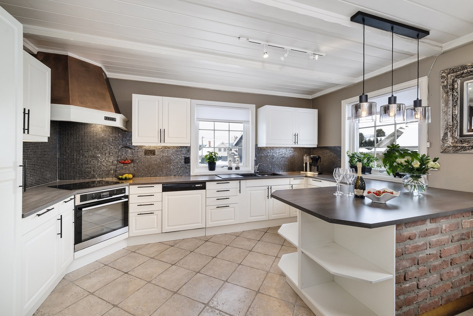 Kjøkkenet fremstår som et lyst, innbydende og svært funksjonelt rom med en gjennomført kombinasjon av klassiske og moderne elementer. Galleribilde