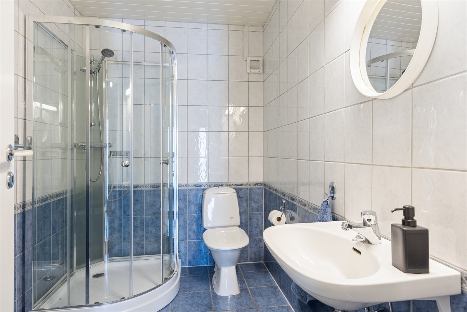 Badet i hoveddelens underetasje har fliser på gulv og vegger, samt dusjkabinett. Galleribilde