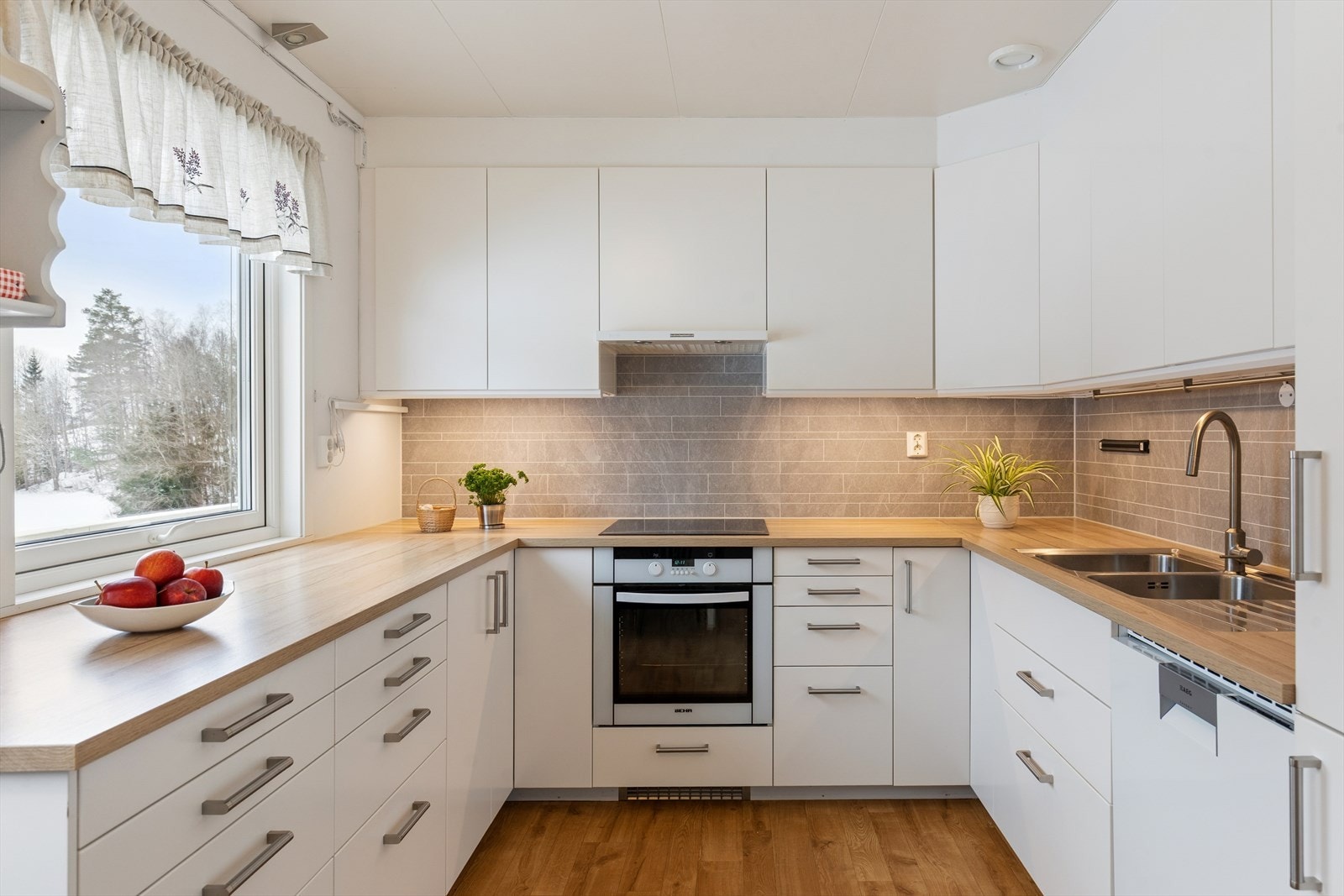 Innredningen har malte fronter, laminat benkeplate og integrerte hvitevarer. Galleribilde