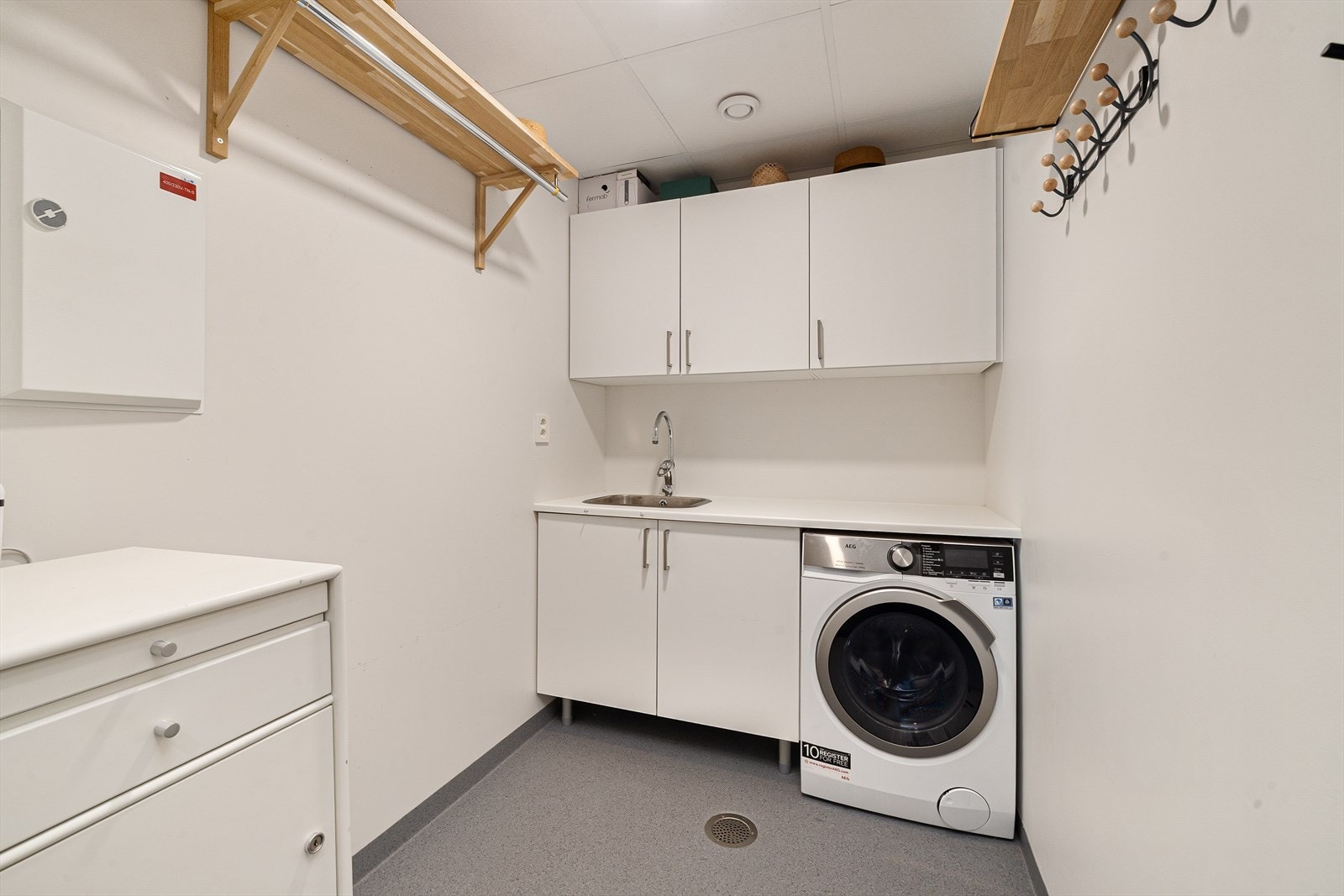 Vaskerom har opplegg for vaskemaskin, og har innredning med nedfelt vask og skap Galleribilde